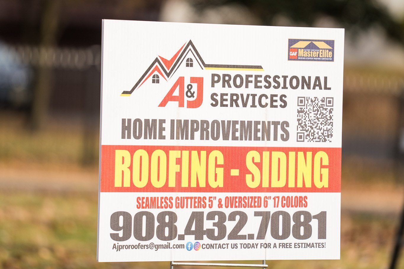 An A&J Professional Services yard sign standing on a front lawn